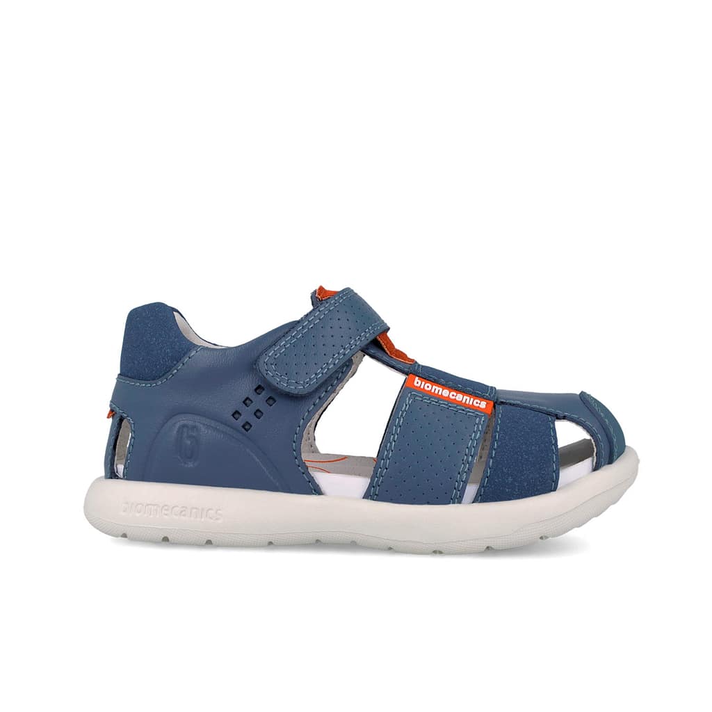 Blue children's sandal with Velcro straps, perforated panels, and a white sole (Biomecanics branding).
