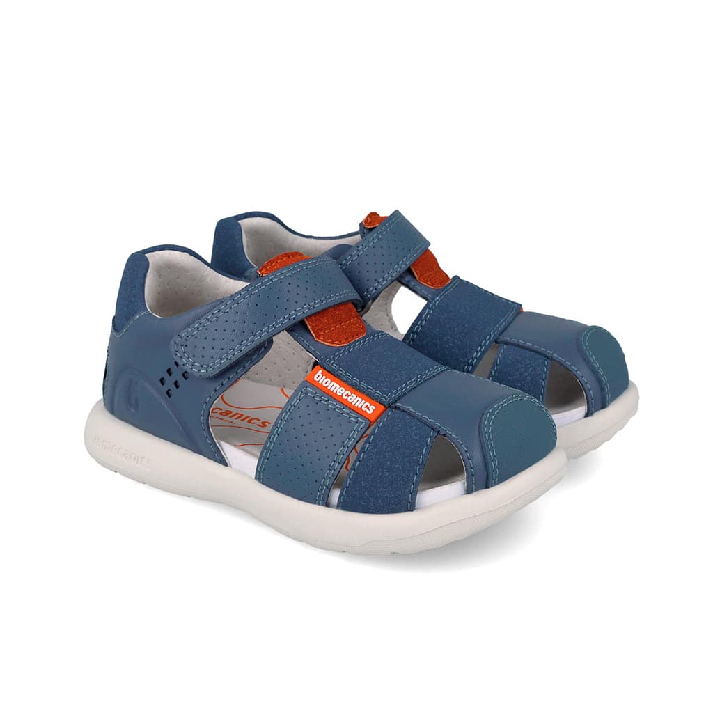 Blue children's sandals with open toes, two Velcro straps, and orange accents on a white sole, brand tag visible.
