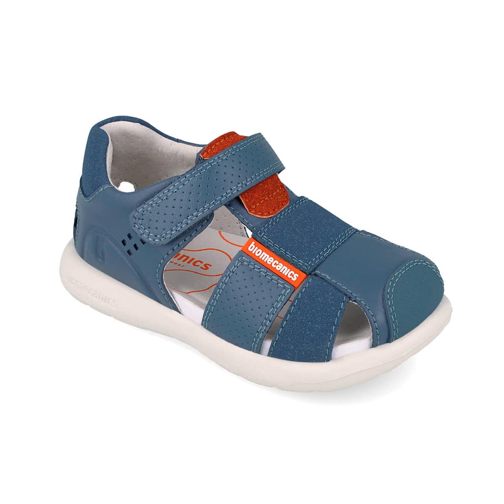 Blue children's sandal with two Velcro straps, orange logo, and a white sole. Perforated panels and closed toe for support.