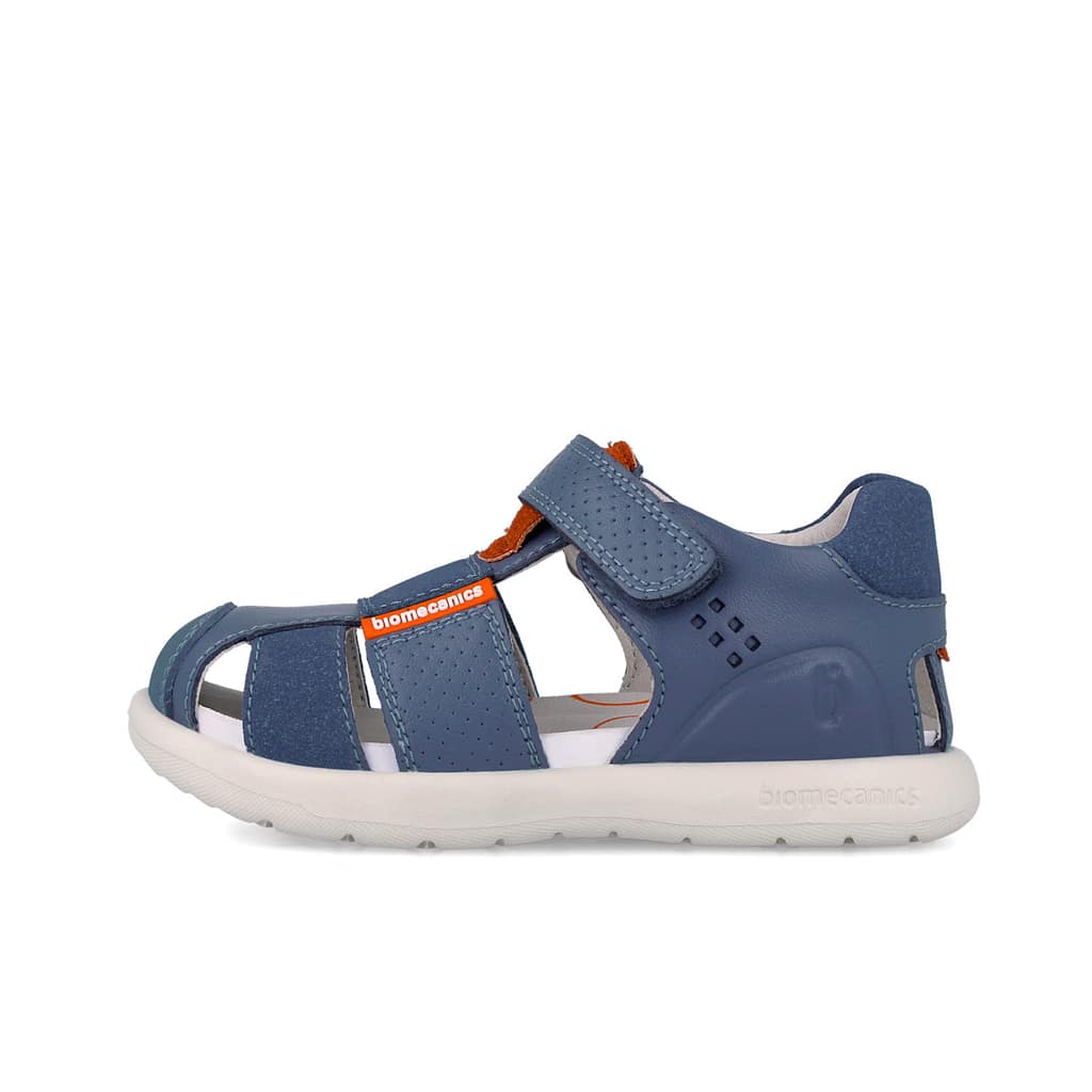 Blue children's sandal with Velcro straps and white sole, brand Biomecanics visible on strap.