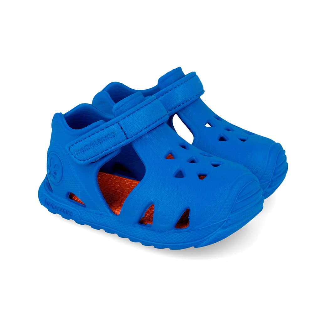 Blue open-toe toddler sandals with ventilation holes and a Velcro strap, orange inner sole visible